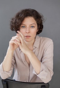 a woman sitting on a chair with her hands on her hips