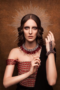 a woman is posing with a necklace and earrings