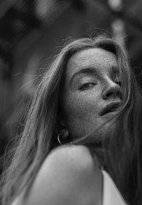 a black and white photo of a woman with freckles