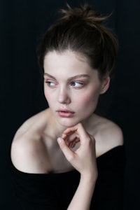 a young woman posing with her hand on her chin