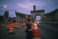 a woman standing next to a traffic cone